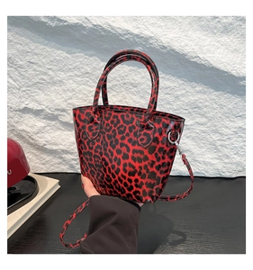 Gros plan détaillé d'un sac seau léopard rouge et noir avec boucle métallique