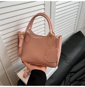 Détails du sac seau rose en cuir grainé avec pendentif chiot et bandoulière réglable