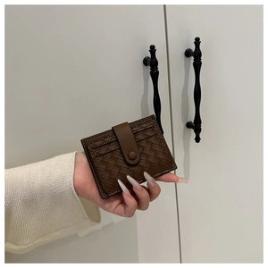 Close-up of a brown woven texture card holder with a snap button leather strap