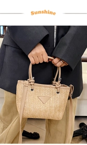Close-up of woven straw tote bag with leather trim, triangular logo and zipper detail