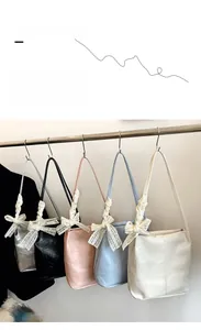 Lace bow shoulder bags shown in silver, black, pink, blue, and cream colors