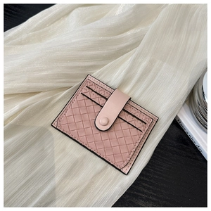 Detailed view of pink woven leather card holder texture with snap button closure