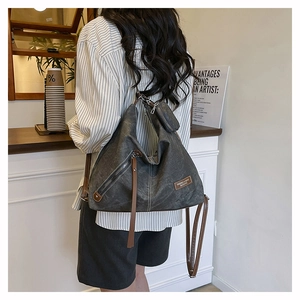 Detail of charcoal grey canvas hobo bag with brown leather accents and coin purse