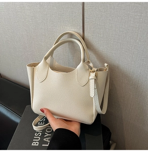 Détail du sac cabas en similicuir grainé blanc crème avec des finitions dorées brillantes