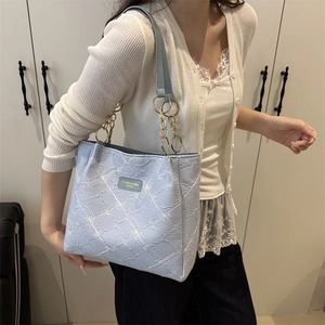 Sac fourre-tout matelassé bleu clair avec chaîne dorée, porté comme sac à bandoulière
