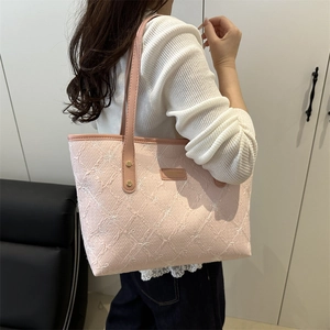 Pink quilted tote bag with floral bow embroidery and slim straps for casual style