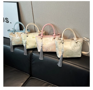 Detailed view of four mini bucket bags with Chinese embroidery and tassel accents