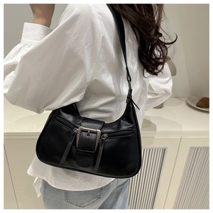 Detailed view of black crescent shoulder bag with silver buckle on a modern white shirt