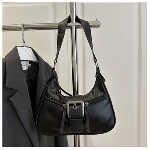 Close-up of black crescent shoulder bag with metallic buckle and zipper detailing