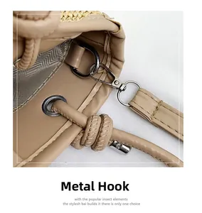 Detail of silver metal hook and drawstring on a beige woven summer bucket bag
