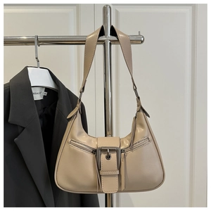 Detail of beige hobo bag with vintage metal buckles and symmetrical double zip pockets