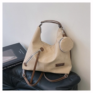 Detail of beige suede tote bag with leather straps and mini round coin purse