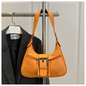 Detailed view of the bright orange Y2K shoulder bag featuring a large square metal buckle