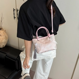 Pink satin bucket bag with silver floral jacquard and long grey tassel on model