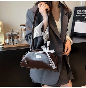 Chic dark brown faux leather shoulder bag featuring a decorative white lace bow detail