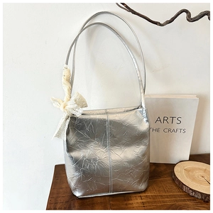 Silver metallic wrinkled tote bag featuring a delicate white lace bow detail