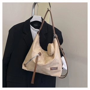 Detail of beige hobo bag with fringe zipper, contrast strap and mini round pouch