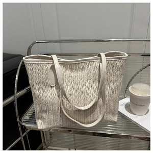 Détail du sac cabas tissé crème avec texture à chevrons et anses en cuir fin