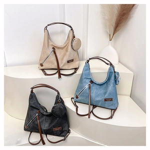 Close-up of vintage canvas tote bags with leather straps and decorative zip details