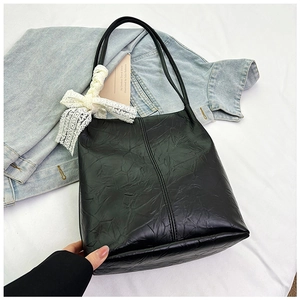 Detail of black pleated PU leather tote bag with white lace bow charm for daily commuting