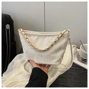 Detail of cream white nylon shoulder bag with golden chain handle and fashion logo plate