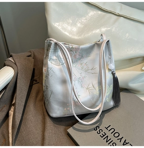 Detailed shot of silver satin tote bag with traditional Chinese floral and bamboo prints