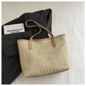 Vue de dessus d'un sac cabas tissé avec anses en cuir marron et texture en paille