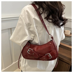 Détail du sac hobo en cuir verni bordeaux avec boucles vintage et finition brillante