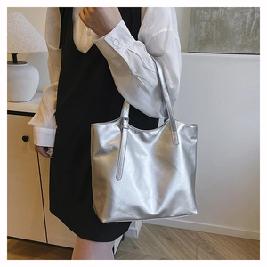 Silver metallic tote bag on model showing large capacity and adjustable shoulder strap