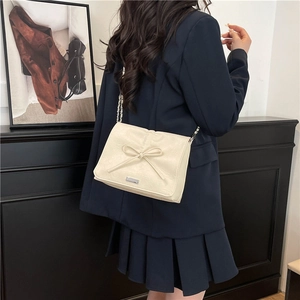 Fashionable creamy white shoulder bag with bow detail and metal chain strap for women