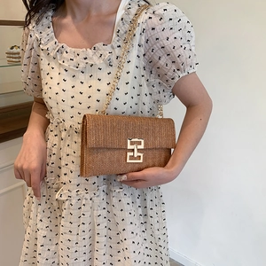 Brown woven crossbody bag with gold chain strap and metallic buckle for summer vacation