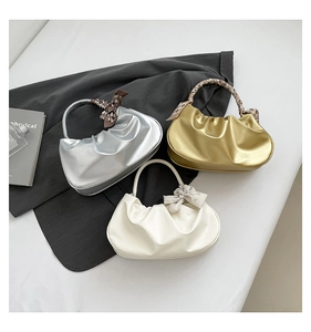 Tre borse nuvola a pieghe in argento, oro e bianco con sciarpe di seta su un blazer