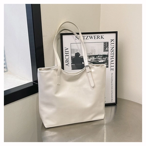 Close-up of white minimalist tote bag showing premium PU leather texture and shoulder strap