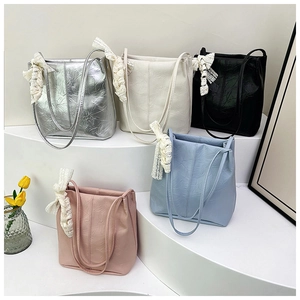 Detail of five large-capacity bucket bags with lace bows and textured pleated leather