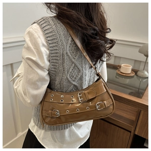 Détail du sac en similicuir caramel avec sangles à boucles et œillets métalliques