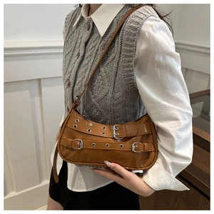 Sac baguette en cuir PU caramel avec boucles décoratives porté à l'épaule par un mannequin
