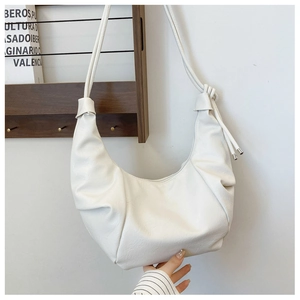 Detail of white crescent shoulder bag with pleated PU leather and knotted strap accents