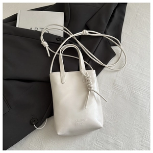 Détail d'un mini sac en cuir blanc mat avec gaufrage Fashion Bags et bandoulière nouée