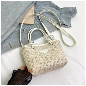 Detail of handwoven straw bucket bag with white leather straps and fashion triangle tag