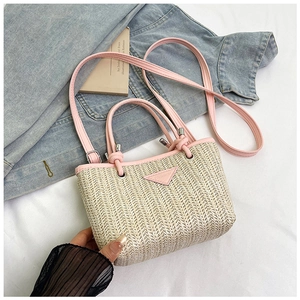 Detail of summer straw bucket bag with pink leather trim and FASHION logo plaque