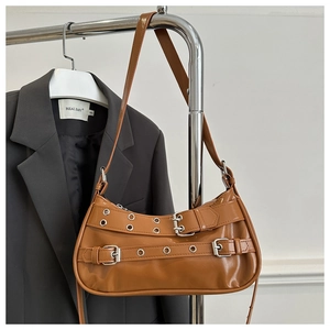 Détail du sac baguette en simili cuir marron avec boucles argentées et œillets