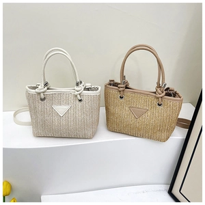 Detail of woven straw tote bags with leather handles and fashion triangle patch