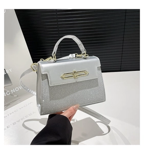 Detail of silver sequin handbag with gold rectangular twist lock and top handle