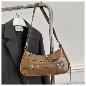 Détail du sac en cuir marron brillant avec boucles parallèles et œillets argentés