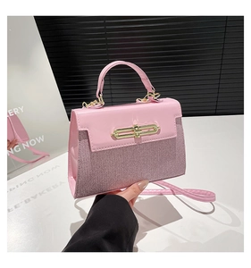 Detailed view of pink crossbody bag showing shiny glitter fabric and gold twist lock