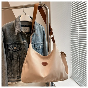 Detailaufnahme der beige Hobo-Tasche mit modischem Lederpatch und breitem Schultergurt