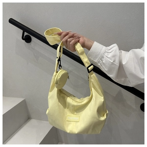 Détail du sac hobo en nylon jaune clair avec bandoulière réglable et petit porte-monnaie