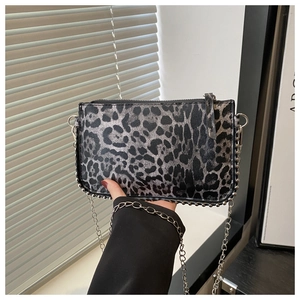 Close-up of leopard print mini bag with silver studs and elegant metal chain strap