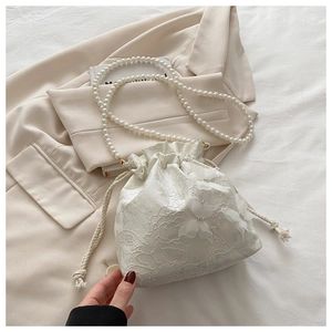 Detail of white lace bucket bag with 3D butterfly appliqué and pearl chain strap