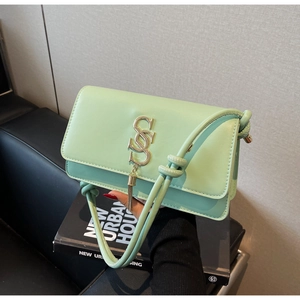 Detail of mint green square bag showing golden 'S' logo and chain tassel fringe